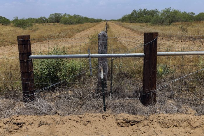 El lugar donde se encontraba un tonel de agua para migrantes con bidones cerrados de agua se ve en un tramo nuevo de cerca junto a una propiedad privada en el condado rural Jim Hogg, Texas, el martes 25 de julio de 2023.