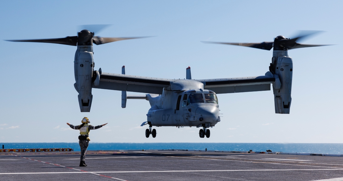 El marinero de primera Keely Hagedoorn, de la Real Armada de Australia, guía a un MV-22 Osprey de la Infantería de Marina de Estados Unidos en prácticas de despegue y aterrizaje sobre la cubierta del HMAS Adelaide en las Islas Whitsunday australianas, el 7 de agosto de 2023, durante los ejercicios militares Sea Raider.