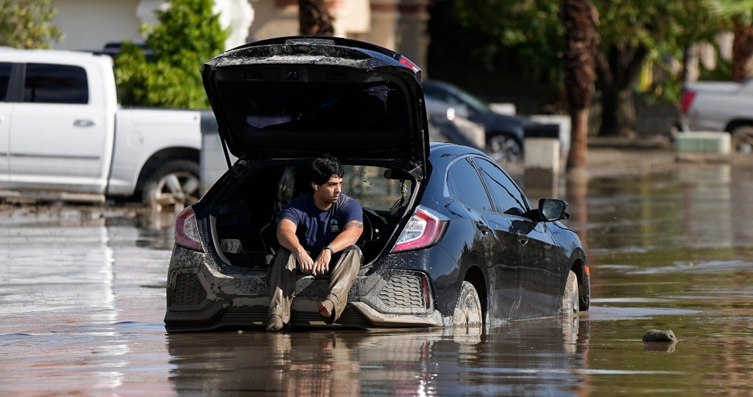 Dorian Padilla permanece en su automóvil mientras aguarda la llegada de una grúa después de que quedó atascado en el lodo, el lunes 21 de agosto de 2023, en Cathedral City, California. Foto: Mark J. Terrill, AP