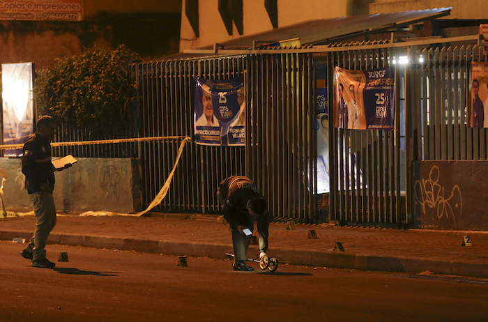 Investigadores de la policía caminan sobre la escena a las afueras del colegio en donde el candidato presidencial Fernando Villavicencio fue asesinado a tiros a la salida de un mítin electoral en un colegio en Quito, Ecuador, el miércoles 9 de agosto de 2023.