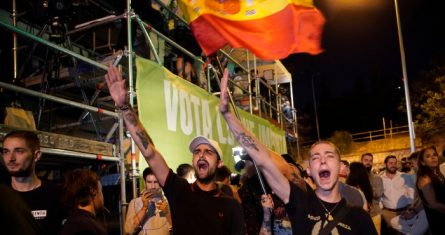 Jóvenes alzan el brazo derecha para hacer el saludo fascista ante la sede del partido de ultraderecha Vox en Madrid, mientras seguidores del partido esperan a los resultados de las elecciones generales españolas el domingo 23 de julio de 2023.