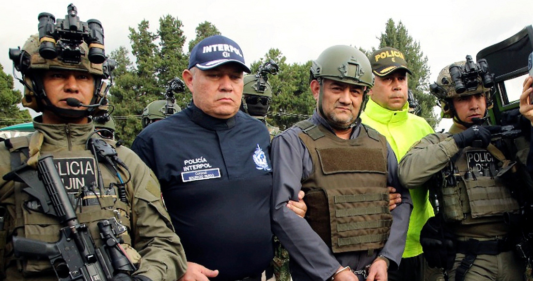 La policía escolta a Dairo Antonio Úsuga (al frente segundo de la derecha), líder del Clan del Golfo, para extraditarlo a Estados Unidos, en un aeropuerto militar en Bogotá. Foto provista por la Oficina de Prensa de la Presidencia de Colombia el 4 de mayo de 2022.