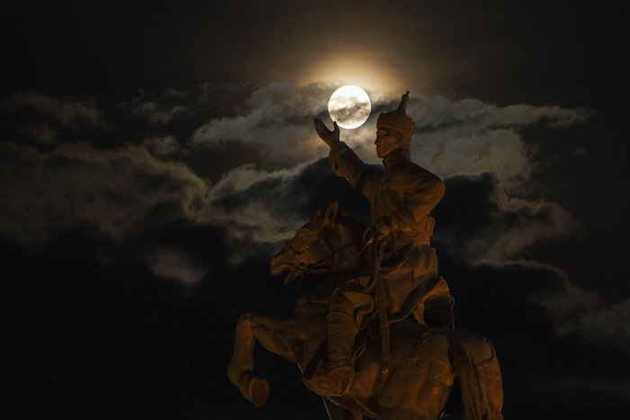 La súperluna detrás de la estatua de Damdin Sujbaatar, en la Plaza Sujbaatar, de Ulán Bator, Mongolia, el miércoles 30 de agosto de 2023.