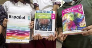 Menores muestran libros de texto en una escuela de Nuevo León.