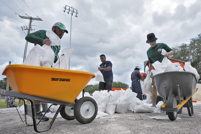 Miembros del departamento de parques y jardines de Tampa, Florida, ayuda a los residentes con costales de arena antes de la llegada de la tormenta "Idalia", el 28 de agosto de 2023, en Tampa, Florida.