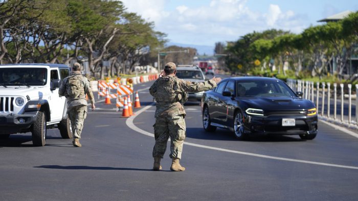 Personal de la Guardia Nacional dirige al tránsito para alejarlo de las áreas afectadas por los incendios forestales, el domingo 13 de agosto de 2023, en Lahaina, Hawai.