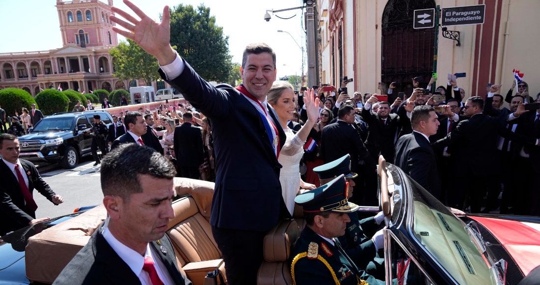 El nuevo Presidente de Paraguay, Santiago Peña, y su esposa, Leticia Ocampos, saludan desde un automóvil mientras se dirigen a la Catedral el día de la asunción de Peña en Asunción, Paraguay, el martes 15 de agosto de 2023. Foto: Jorge Saenz, AP