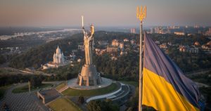 La bandera ucraniana ondea mientras trabajadores instalan el escudo del país en la estatua más alta del país, la estatua de la Madre Ucrania, luego de que retiraron el martillo y la hoz soviéticos, el domingo 6 de agosto de 2023, en Kiev Foto: Efrem Lukatsky, AP