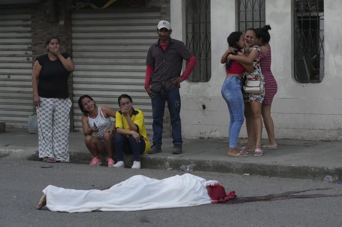 Varias personas lloran junto al cuerpo de un hombre, asesinado en circunstancias desconocidas, en una calle de Durán, Ecuador, el 21 de julio de 2023.