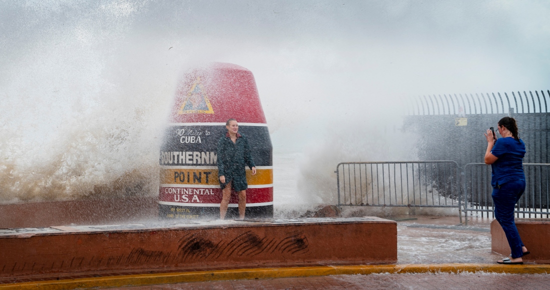 Visitantes de la boya del punto más meridional de EU desafían las olas que se hicieron más fuertes a causa del huracán "Idalia" el martes 29 de agosto de 2023 en Key West, Florida.