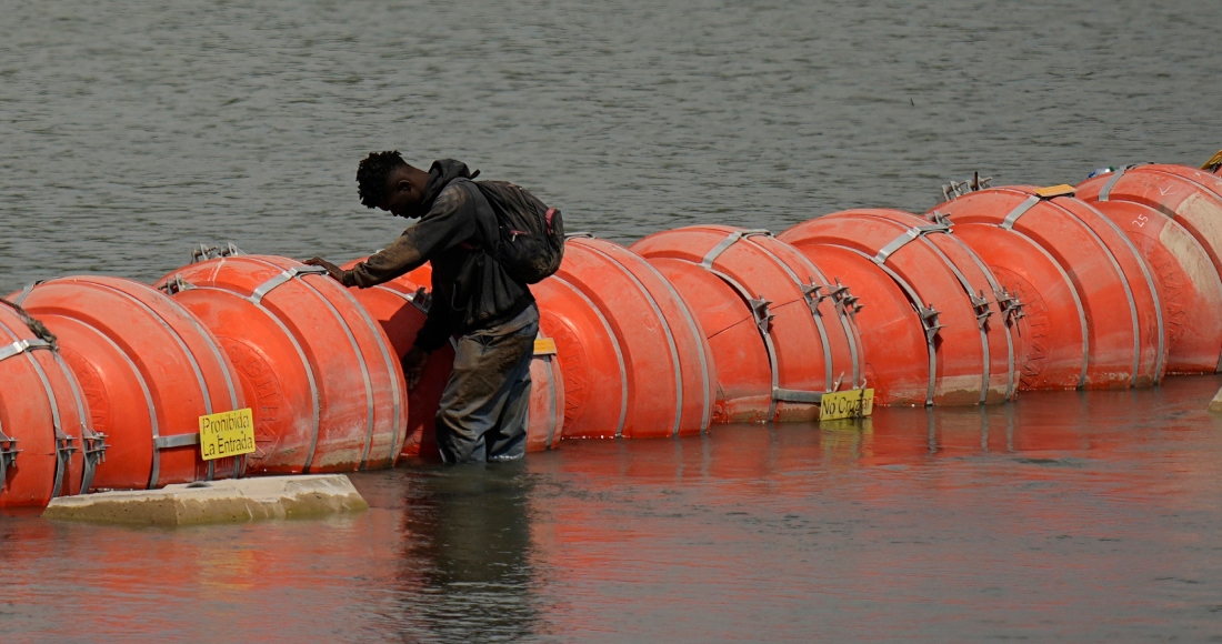 Un migrante colombiano frente a la barrera flotante de boyas mientras trata de cruzar el río Bravo (Grande) de México a Estados Unidos, el lunes 21 de agosto de 2023, en Eagle Pass, Texas. Foto: Eric Gay, AP