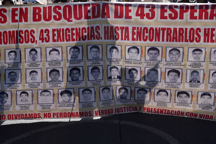 Familiares y simpatizantes de los 43 estudiantes de Ayotzinapa marchan con un gran cartel que muestra sus fotografías y nombres por el noveno aniversario de su desaparición, en Ciudad de México, el martes 26 de septiembre de 2023.