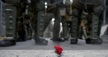 La policía se para frente a una flor colocada en la calle durante una manifestación que marca el 50 aniversario de un golpe militar liderado por el general Augusto Pinochet frente al palacio presidencial de La Moneda en Santiago, Chile, el domingo 10 de septiembre de 2023.