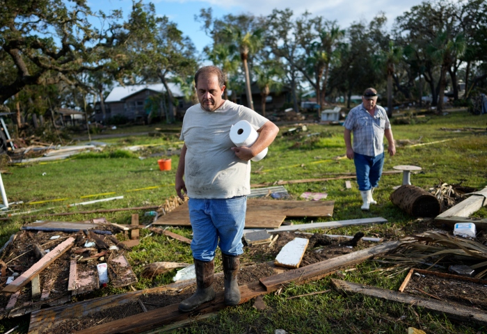 Buddy Ellison (izquierda) y su padre Dan buscan entre los restos esparcidos por su propiedad en Horseshoe Beach, Florida, el 31 de agosto de 2023, un día después del paso del huracán Idalia. Foto: Rebecca Blackwell, AP