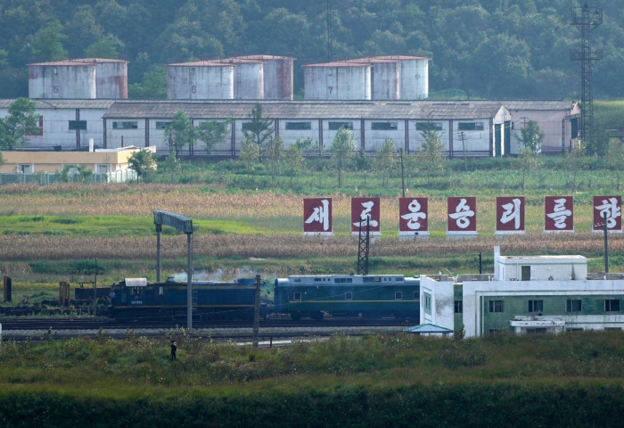 Un tren verde con destellos en amarillo, similar al que utilizó el gobernante norcoreano Kim Jong Un en sus viajes previos, pasa frente a un letrero con la leyenda "Hacia una nueva victoria", en la frontera de Corea del Norte con Rusia y China, desde la plataforma panorámica Tres Reinos de Yiyanwang, el lunes 11 de septiembre de 2023, en Fangchuan, en la provincia de Jilin, en el noreste de China. Foto: Ng Han Guan, AP