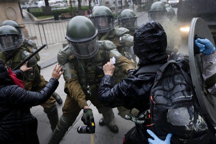 Manifestantes chocan con la policía durante una marcha que conmemora el 50 aniversario de un golpe militar liderado por el general Augusto Pinochet frente al palacio presidencial de La Moneda en Santiago, Chile, el domingo 10 de septiembre de 2023. 