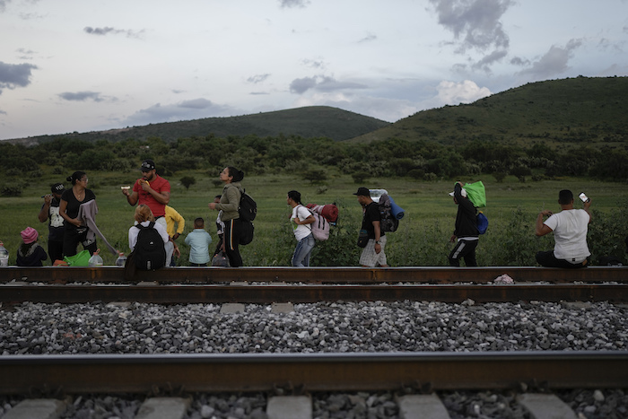 Migrantes caminan junto a las vías a la espera de que pase un tren para subir a bordo de un vagón para dirigirse al norte del país, en Huehuetoca, México, el 19 de septiembre de 2023.