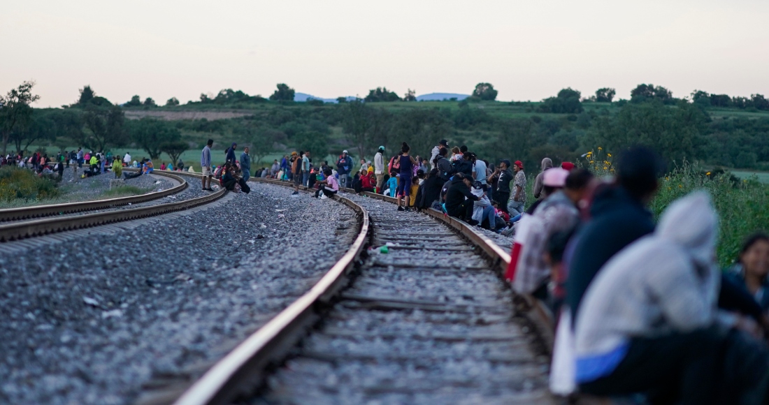 Migrantes esperan a lo largo de las vías con la esperanza de subir a un tren de carga con dirección al norte, uno que se detenga el tiempo suficiente para que puedan subirse, el 19 de septiembre de 2023, en Huehuetoca, México.