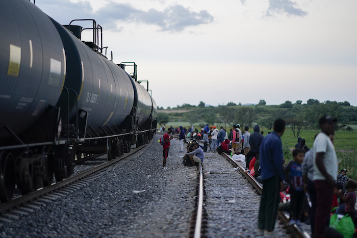 Migrantes ven pasar un tren mientras esperan a lo largo de las vías con la esperanza de subir a un tren de carga que vaya hacia el norte, el 19 de septiembre de 2023, en Huehuetoca, México.