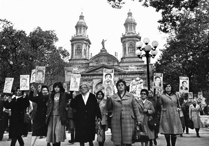 Mujeres protestan mostrando fotos de familiares desaparecidos tras su detención, en la principal plaza de Santiago, Chile, en 1983. 