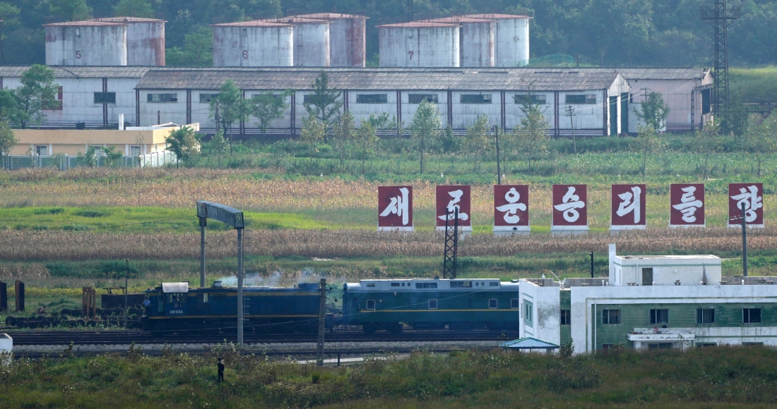 Un tren verde con destellos en amarillo, similar al que utilizó el gobernante norcoreano Kim Jong Un en sus viajes previos, pasa frente a un letrero con la leyenda "Hacia una nueva victoria", en la frontera entre Corea del Norte con Rusia y China, desde la plataforma panorámica Tres Reinos de Yiyanwang, el lunes 11 de septiembre de 2023, en Fangchuan, en la provincia de Jilin, en el noreste de China. Foto: Ng Han Guan, AP