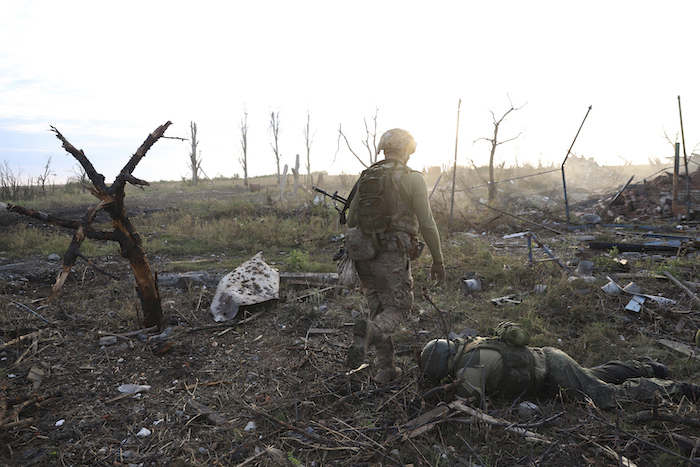 Un comandante de una unidad de la 3ra Brigada de Asalto que utiliza el nombre de Fedia pasa junto al cuerpo de un soldado ruso muerto en Andriivka, en la región de Donetsk, Ucrania, el sábado 16 de septiembre de 2023.