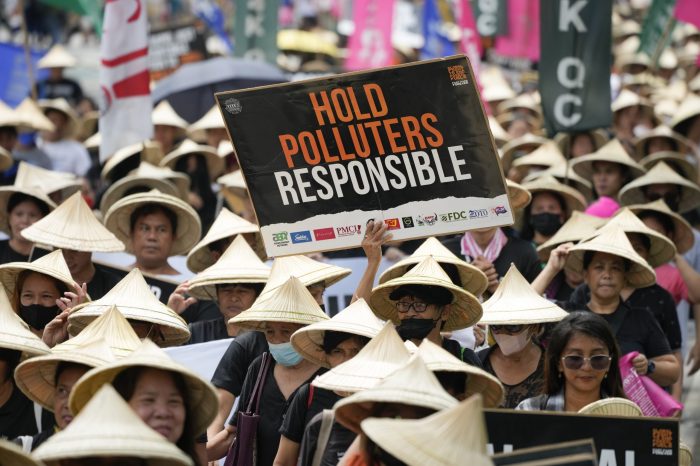 Un manifestante sostiene una pancarta en alto durante una protesta que forma parte de la marcha global contra los combustibles fósiles, el 15 de septiembre de 2023, en la ciudad de Quezon, Filipinas.