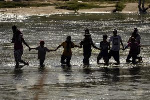 Migrantes forman una cadena humana para cruzar el río Bravo desde México a Estados Unidos, el 21 de septiembre de 2023, en Eagle Pass, Texas. Foto: Eric Gay, AP