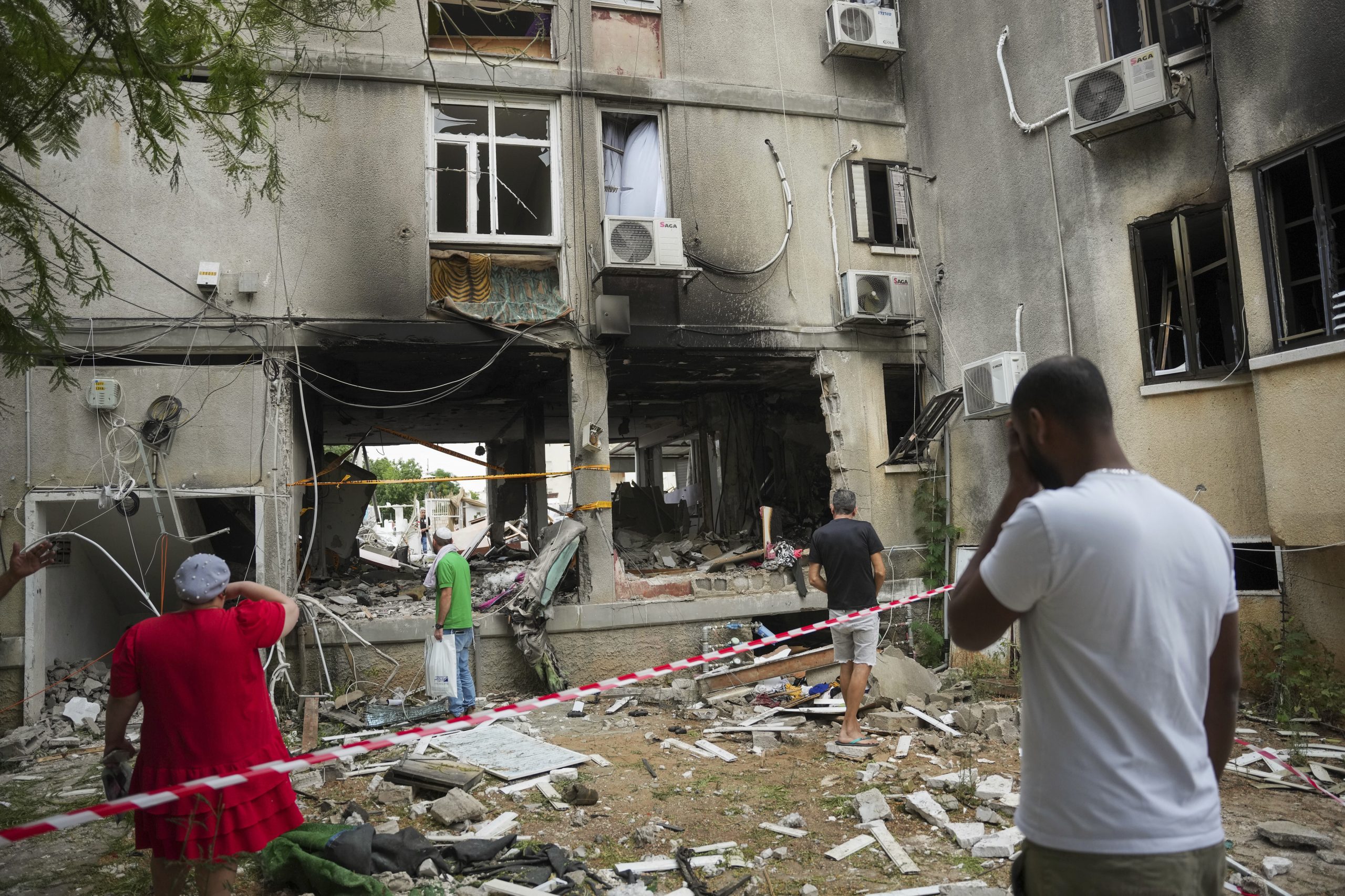 Varios israelíes inspeccionan un edificio residencial dañado que se vio alcanzado por un cohete lanzado desde la Franja de Gaza, en Ashkelon, Israel, el lunes 9 de octubre de 2023. Foto: Erik Marmor, AP