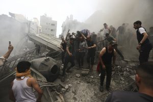 Palestinos sacan un cadáver de entre los escombros de un edificio tras un ataque israelí en el campamento de refugiados de Jebaliya, el lunes 9 de octubre de 2023, en la Franja de Gaza. Foto: Ramez Mahmoud, AP