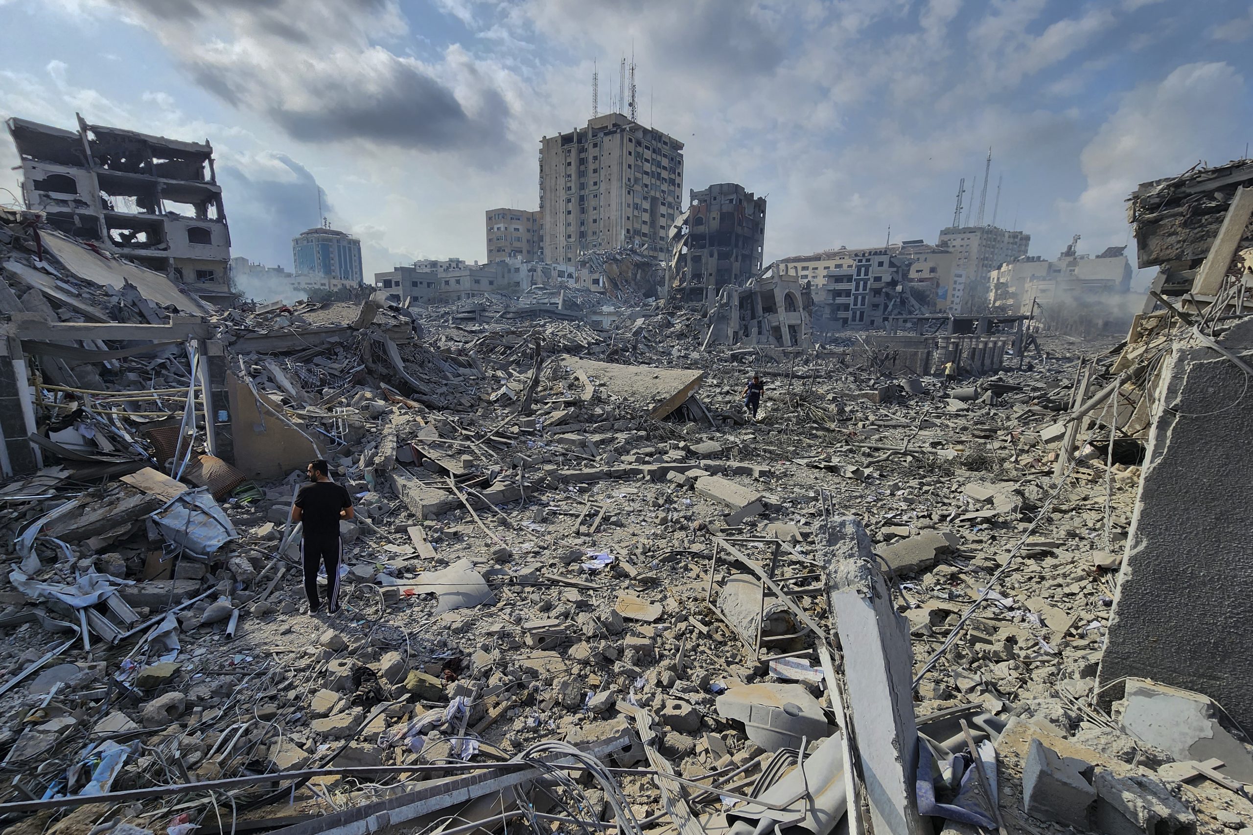 Palestinos caminan sobre los escombros de edificios destruidos por los ataque aéreos de Israel en Gaza, el martes 10 de octubre de 2023. Foto: Hassan Eslaiah, AP