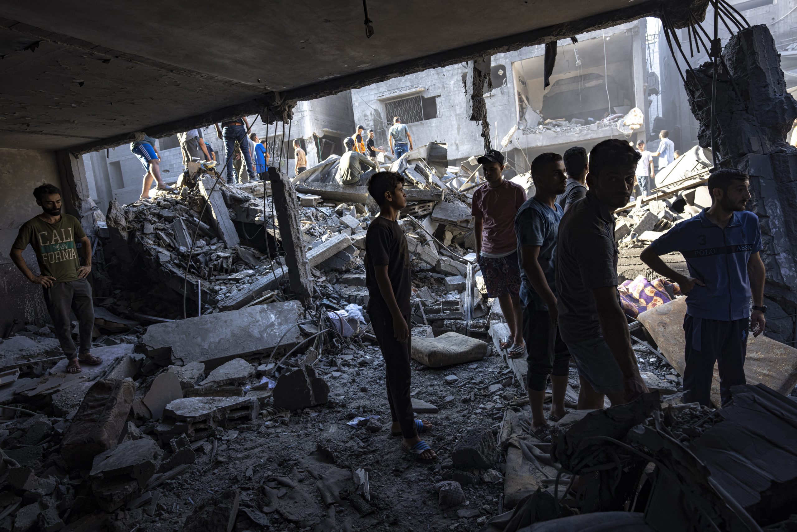 Palestinos buscan cadáveres y sobrevivientes entre los restos de un edificio residencial arrasado tras un ataque aéreo israelí sobre el campo de refugiados de Al Shati, el 12 de octubre de 2023. Foto: Fatima Shbair, AP