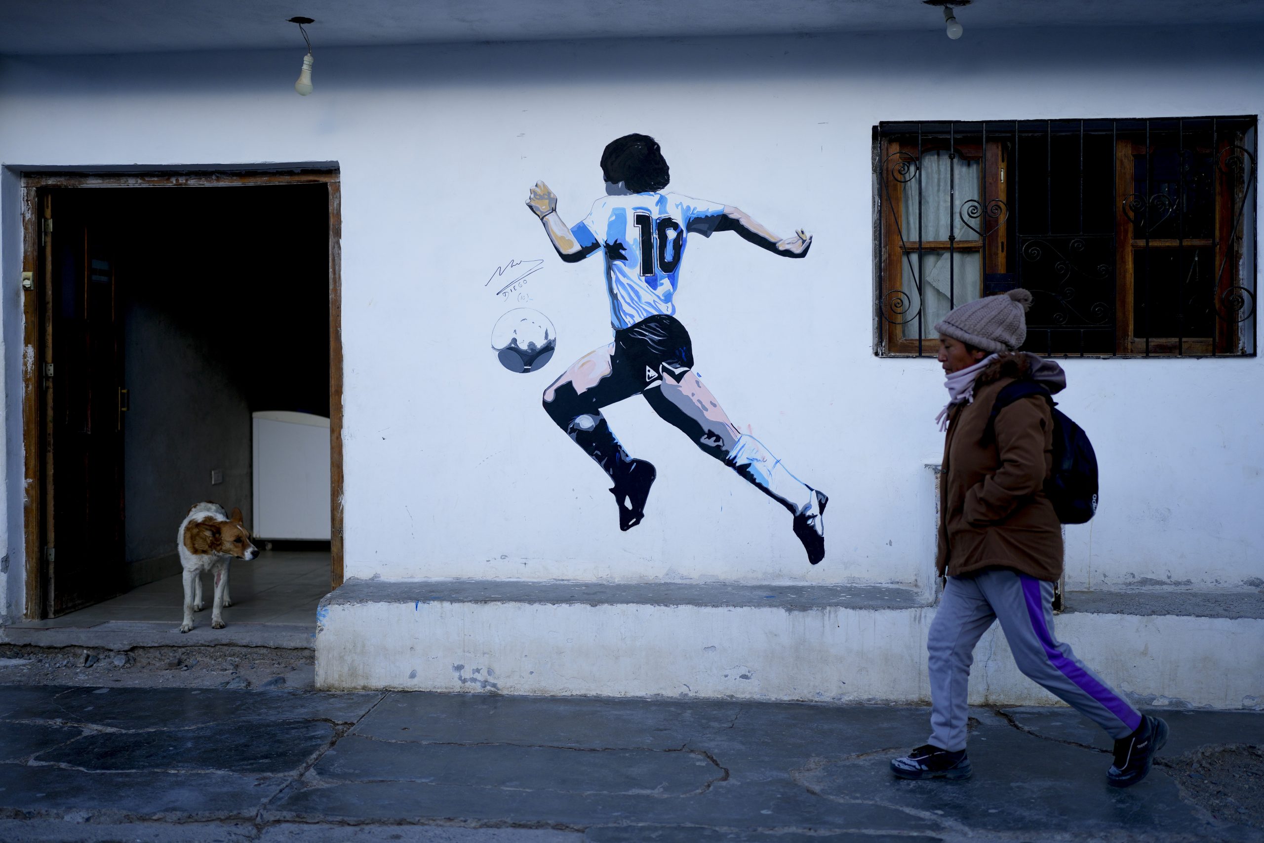 Una mujer camina por delante de un mural de la leyenda del fútbol argentino Diego Maradona, en San Antonio de los Cobres, Salta, Argentina, el martes 3 de octubre de 2023. En San Antonio de los Cobres, el candidato presidencial Javier Milei obtuvo el 60% de los votos en las primarias. Foto: Natacha Pisarenko, AP