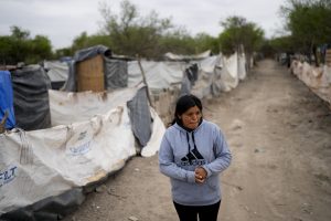 Paola Aguirre afuera de su casa en Salta, Argentina, el miércoles 4 de octubre de 2023. Aguirre, que vive en una casita levantada con maderas cerca de un vertedero, tiene puesta su esperanza en el candidato presidencial Javier Milei. Foto: Natacha Pisarenko, AP