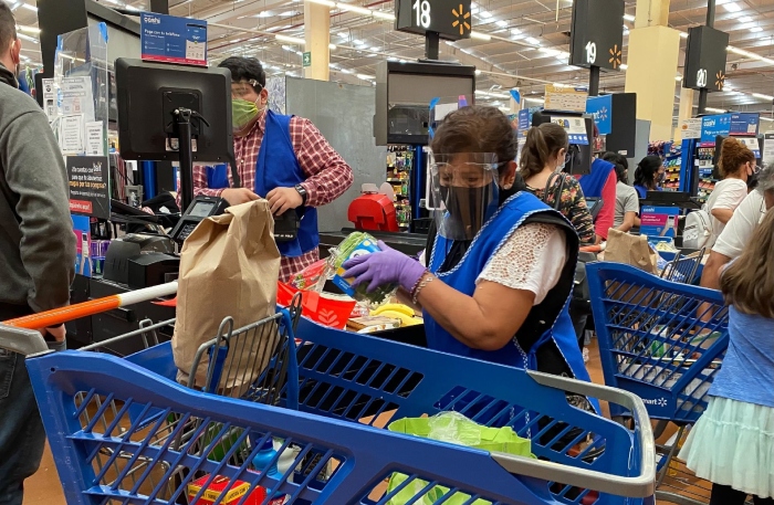 Adultos mayores que trabajan como empacadores en supermercados.