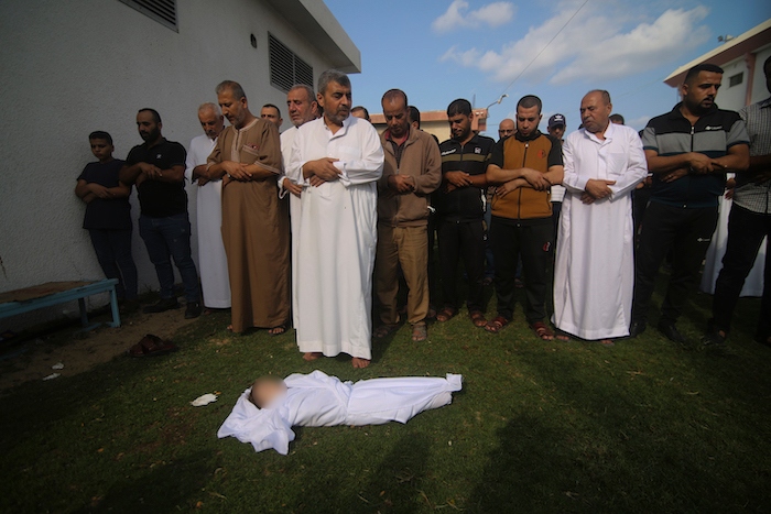 Familiares oran frente al cuerpo de Amir Ganan, quien murió a causa de un ataque aéreo israelí, durante su funeral, el martes 10 de octubre de 2023, en Jan Yunis, en la Franja de Gaza.