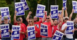 Miembros del sindicato automotor UAW en huelga marchan cerca de una planta de ensamblaje de General Motors, en Delta Township, Michigan, el 29 de setiembre de 2023.