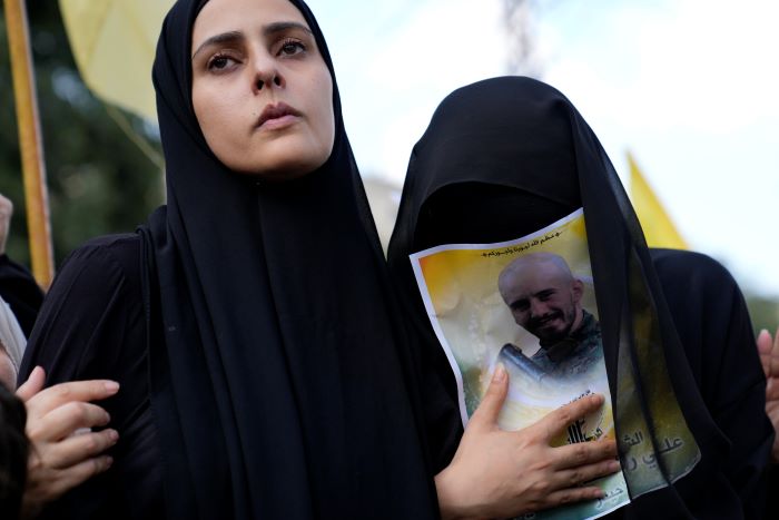 La esposa, a la izquierda, y la hermana del miembro de Hezbollah Ali Ftouni, quien murió en una ofensiva israelí, se lamentan durante su procesión fúnebre, el martes 10 de octubre de 2023, en el poblado de Khirbet Selm, en el sur de Líbano.