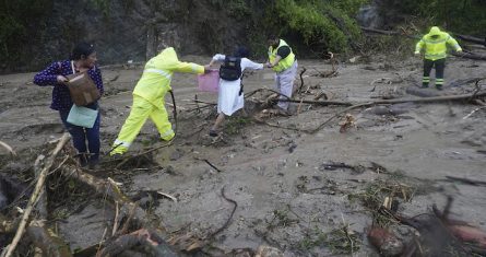 La gente recibe ayuda para cruzar una carretera bloqueada por un deslizamiento de tierra provocado por el huracán "Otis" cerca de Acapulco, México, el miércoles 25 de octubre de 2023.