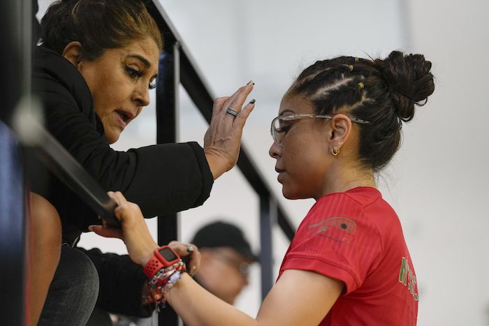 La mexicana Paola Longoria (derecha) recibe la bendición de su madre Leticia López previo a la final de singles ante su compatriota Montserrat Mejía en el ráquetbol​ de los los Juegos Panamericanos en Santiago, Chile, el martes 24 de octubre de 2023.