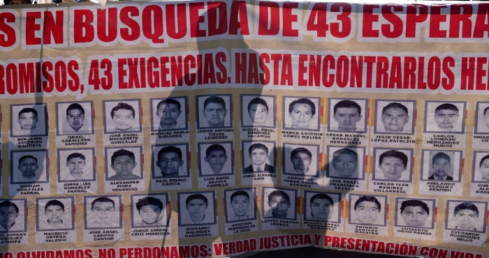 Familiares y simpatizantes de los 43 estudiantes de Ayotzinapa marchan con un gran cartel que muestra sus fotografías y nombres por el noveno aniversario de su desaparición, en Ciudad de México, el martes 26 de septiembre de 2023.