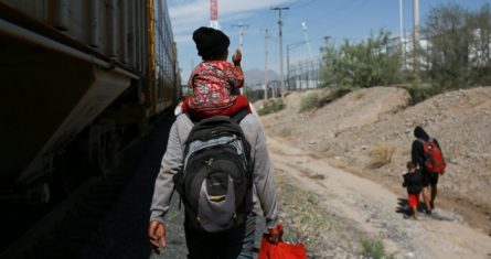 Migrantes caminan junto a un vagón de tren en Ciudad Juárez, México, el jueves 28 de septiembre de 2023.