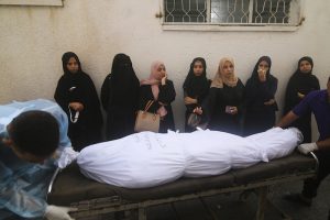 Mujeres palestinas esperan junto al cadáver de una persona que falleció en un bombardeo israelí sobre la Franja de Gaza, en Rafah, el 24 de octubre de 2023.