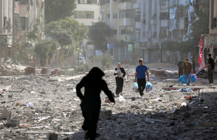 Varios palestinos salen de sus viviendas tras un bombardeo israelí, el lunes 30 de octubre de 2023, en Ciudad de Gaza.