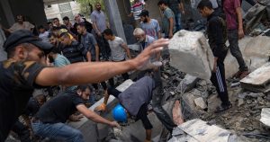 Palestinos buscan sobrevivientes en un edificio destruido por el bombardeo israelí en el campo de refugiados de Rafah, en la Franja de Gaza, el martes 17 de octubre de 2023.