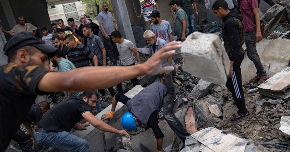 Palestinos buscan sobrevivientes en un edificio destruido por el bombardeo israelí en el campo de refugiados de Rafah, en la Franja de Gaza, el martes 17 de octubre de 2023.