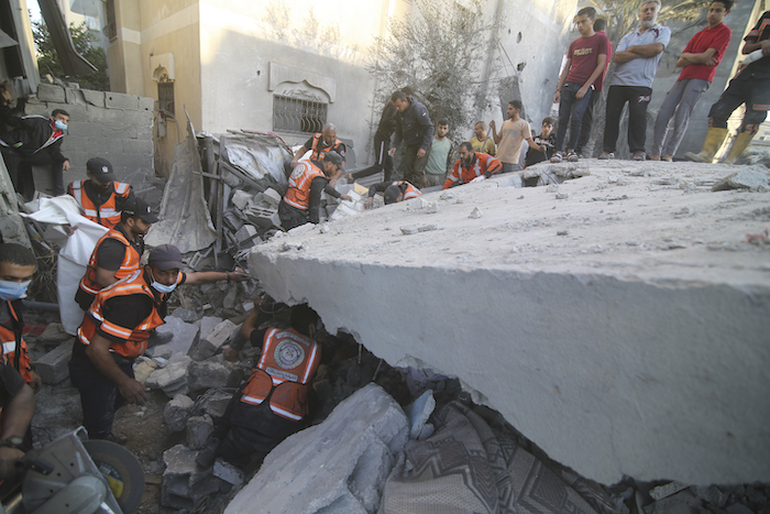 Palestinos buscan sobrevivientes entre los escombros del edificio de la familia Zanon, el cual fue destruido por ataques aéreos israelíes, el sábado 14 de octubre de 2023, en Rafah, Franja de Gaza.