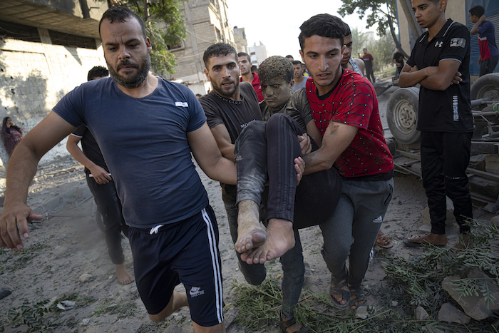 Palestinos llevan a un herido en un ataque aéreo israelí en Khan Younis, en la Franja de Gaza, el lunes 16 de octubre de 2023.