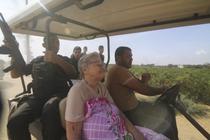 Palestinos transportan a una civil israelí capturada, centro, del kibbutz Kfar Azza a la Franja de Gaza, sábado 7 de octubre de 2023.