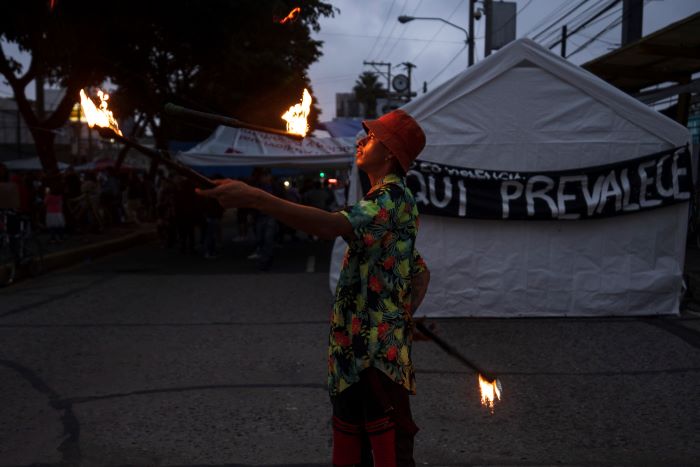 Un artista urbano se prepara antes de actuar frente a la Universidad Nacional en medio de una huelga nacional, en la Ciudad de Guatemala, el miércoles 11 de octubre de 2023.